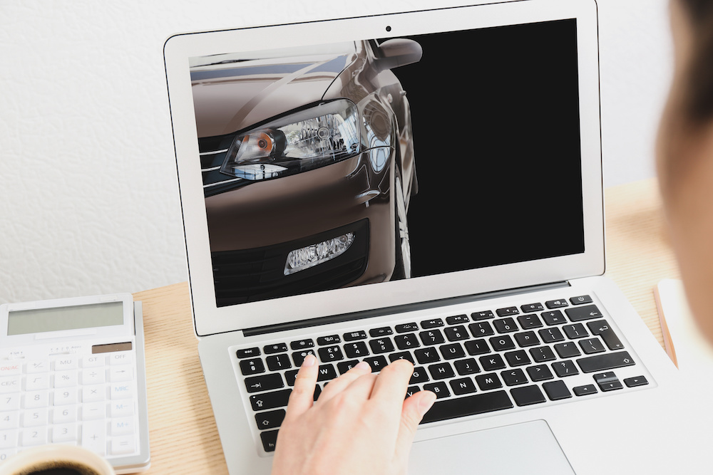 Buying online. Woman choosing car using laptop, closeup view